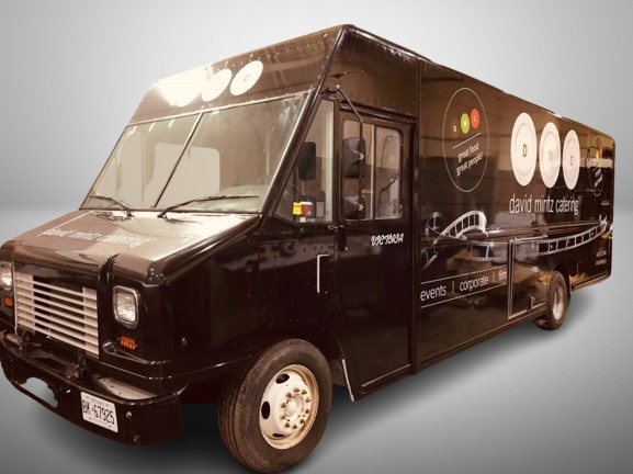 Black food truck wrap in Toronto featuring David Mintz Catering branding with custom vehicle graphics for corporate and event catering promotions.